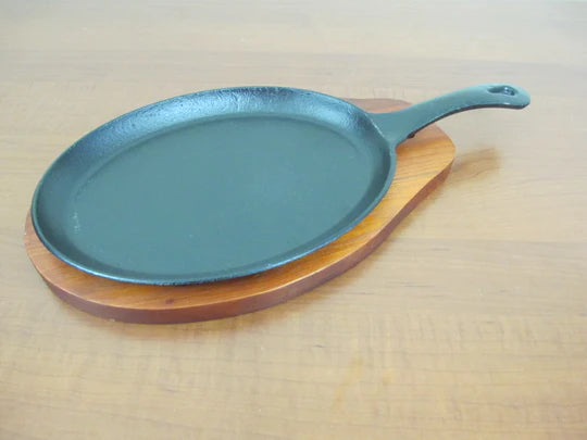 Oval sizzling platter with handle and wooden base