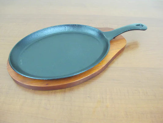 Oval sizzling platter with handle and wooden base